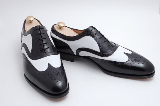 Black and white dress shoes on a light gray background