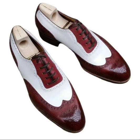 Pair of burgundy and white dress shoes on a white background