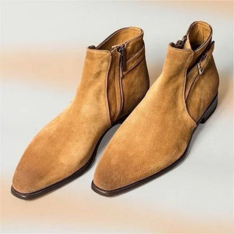 Pair of tan suede ankle boots on a light background
