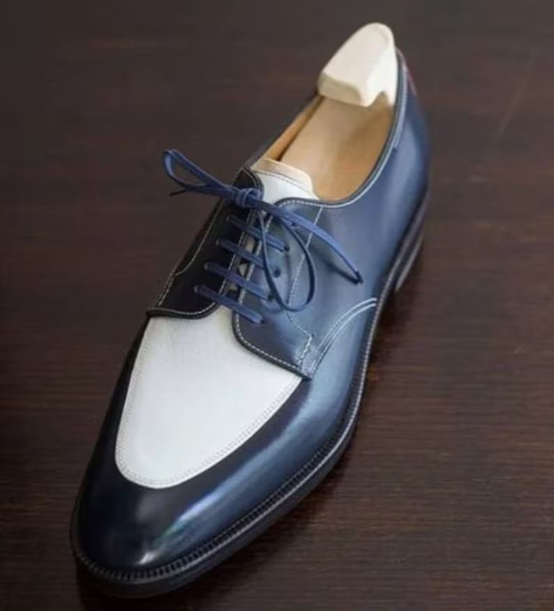navy and white dress shoe on a wooden surface