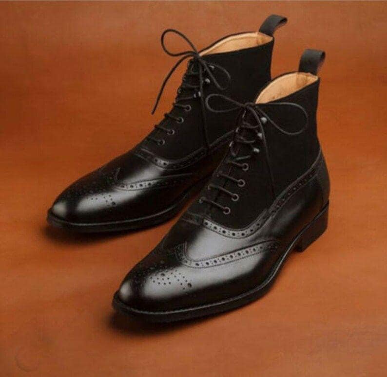 Pair of black leather and suede brogue shoes on a brown background