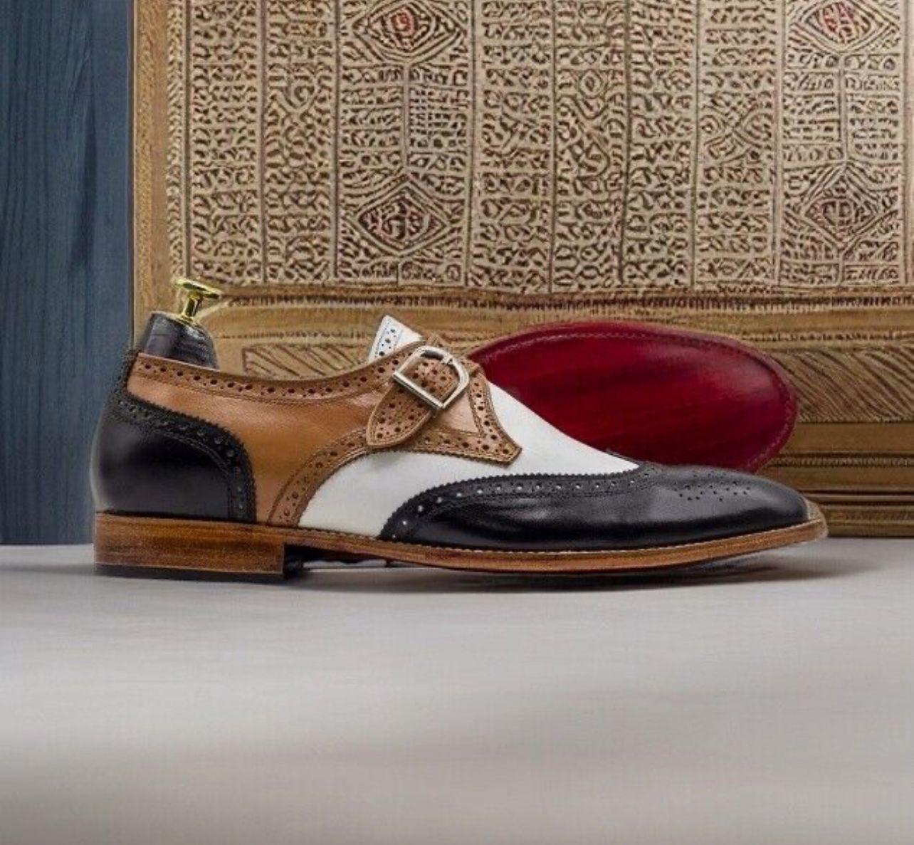 Multicolored dress shoe with brown, black, and white design on a textured surface.
