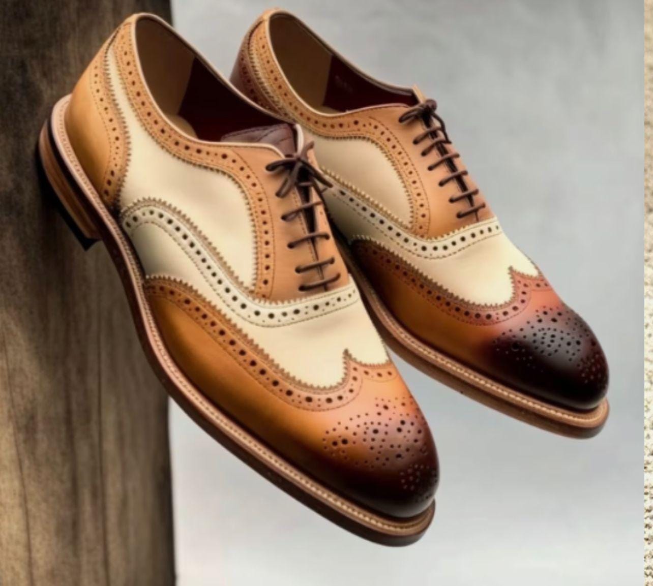 Pair of brown and beige dress shoes on a neutral background