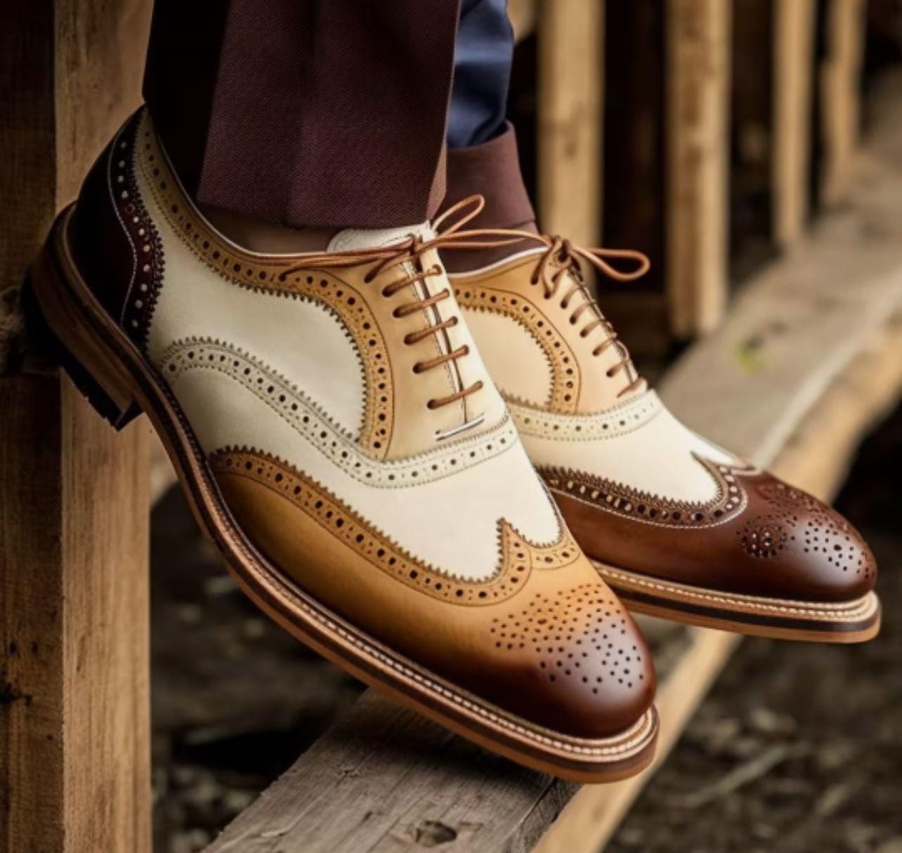 Pair of brown and white dress shoes on a wooden surface