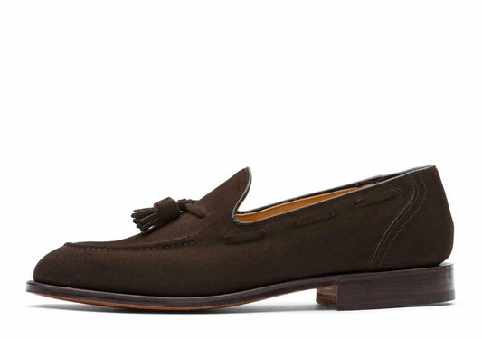 Brown suede loafer with a tassel on a white background