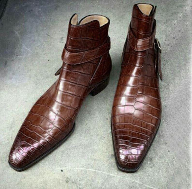 Brown leather boots with crocodile pattern on a gray surface