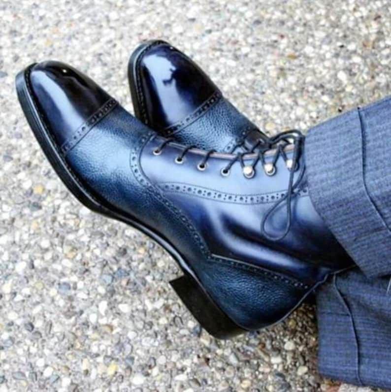 Pair of blue ankle-high boots on a textured surface