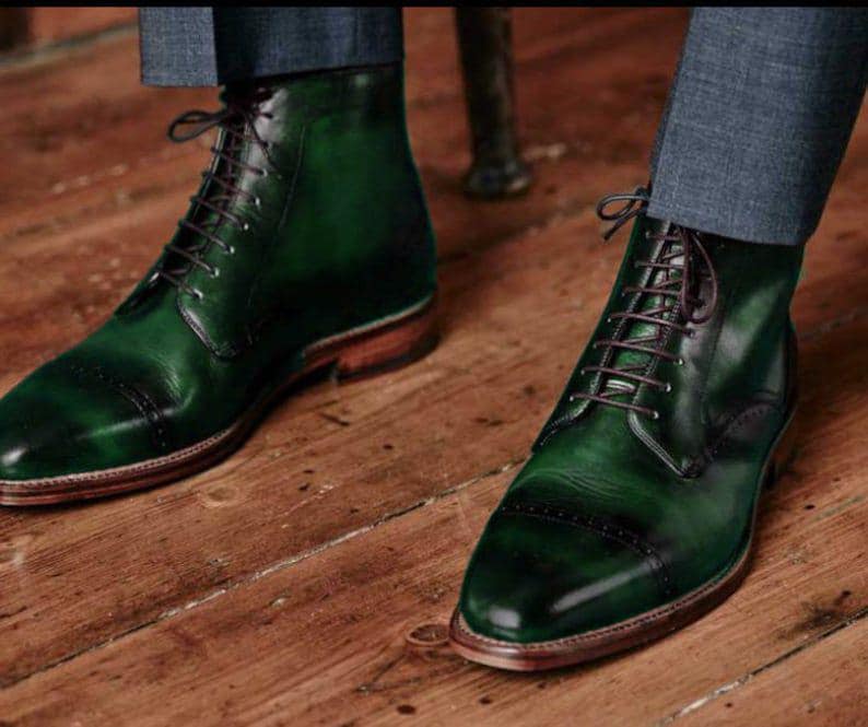 Green leather boots on a wooden floor