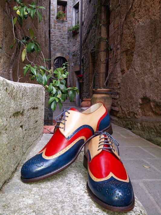 Colorful leather shoes on a stone surface with an old stone building background