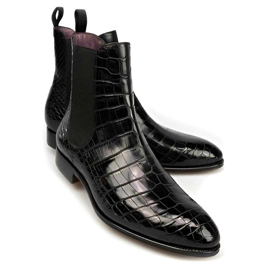 Black crocodile-patterned leather boots on a white background