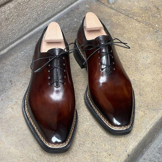 Pair of brown leather dress shoes on a concrete surface