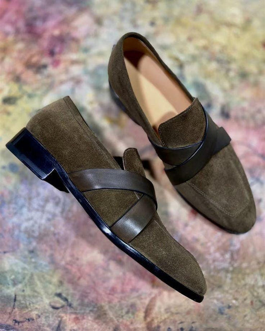 Brown loafers with black soles on a multicolored abstract background